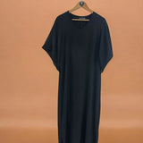 Vestido longo preto com decote V e mangas amplas, visual fluido.