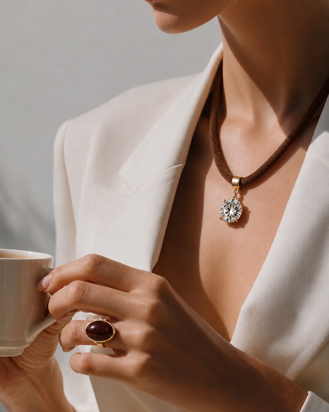 Colar com cordão marrom e pingente redondo com zircônias, acabamento dourado