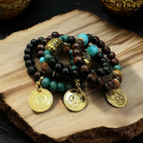 Pulseira Shanti de miçangas escuras e turquesa com pingentes dourados