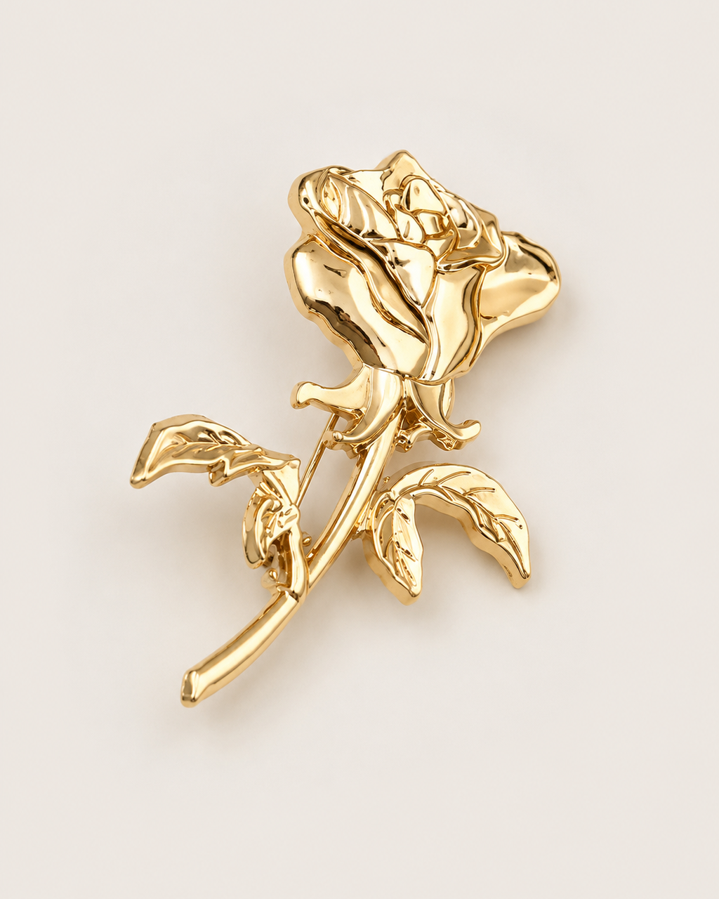 Broche em formato de rosa dourada com folhas e detalhe em relevo