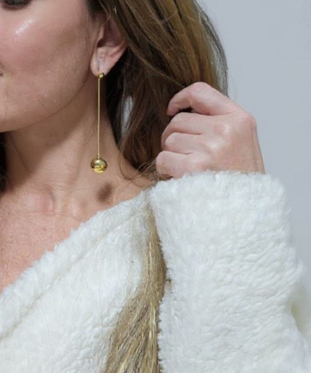 Brinco longo de esfera com haste fina e banho dourado, pendente no lóbulo da orelha