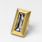 Anel retangular dourado com pedra central transparente e borda texturizada
