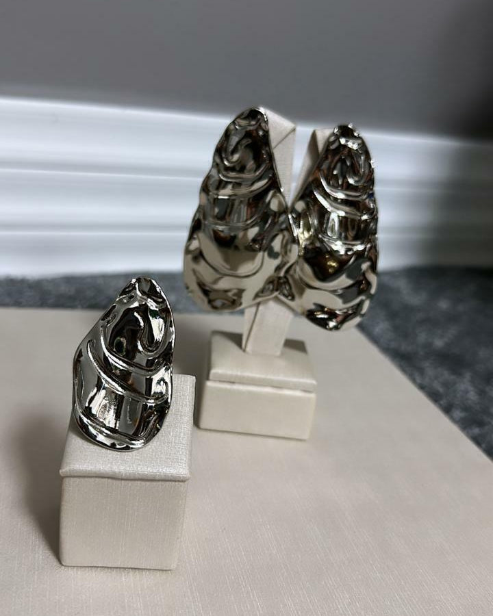Par de anéis prateados com topo ornamentado e detalhe vazado