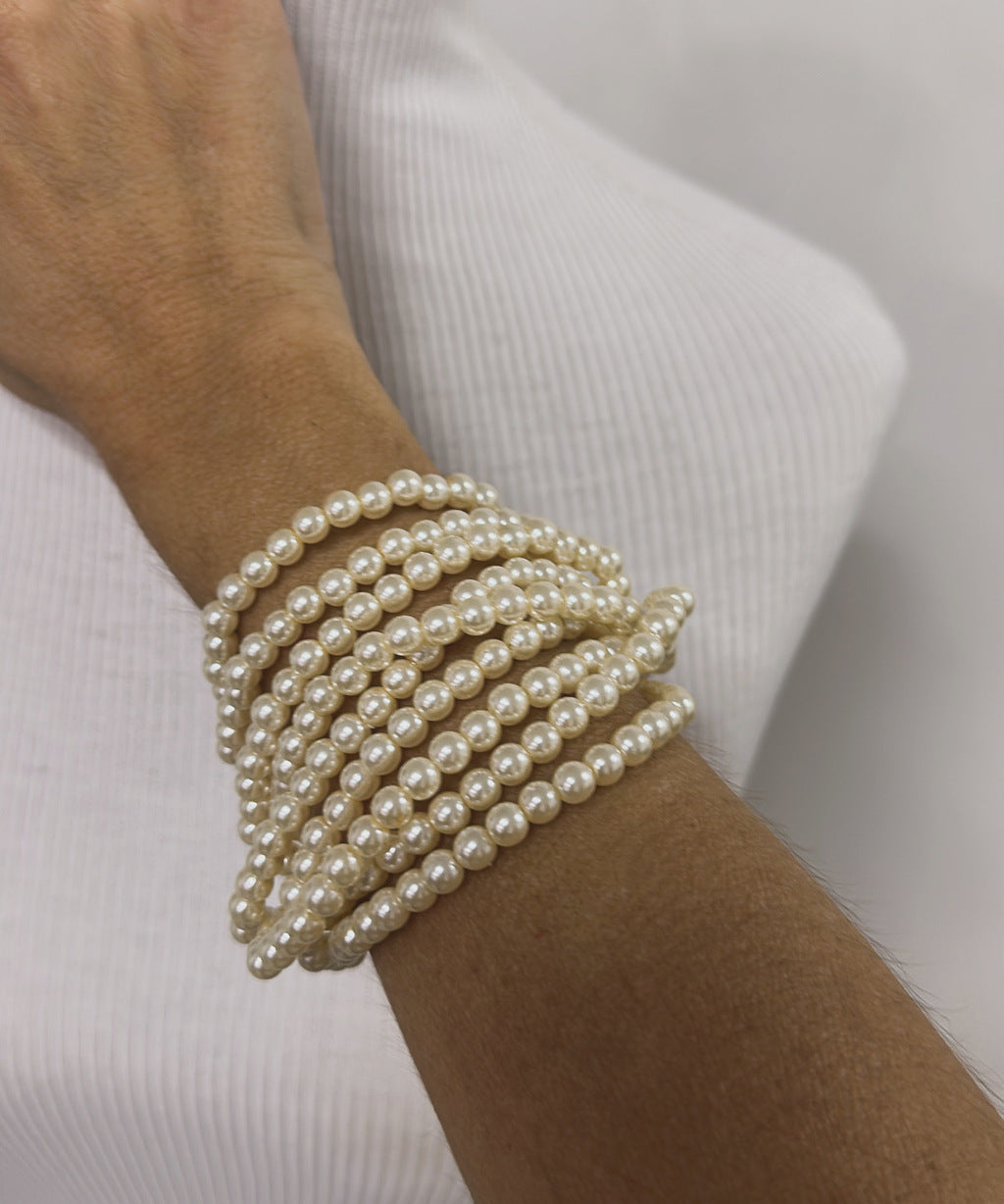 Pulseira de pérolas com várias voltas no pulso