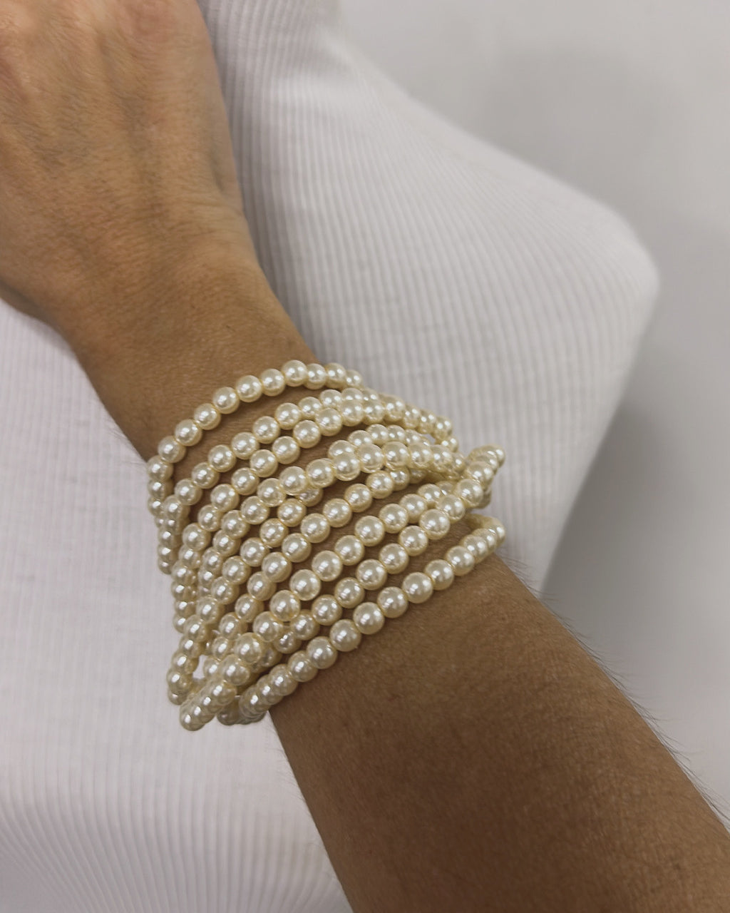 Pulseira de pérolas com várias voltas no pulso