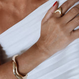 Bracelete dourado ondulado com abertura, vista no pulso
