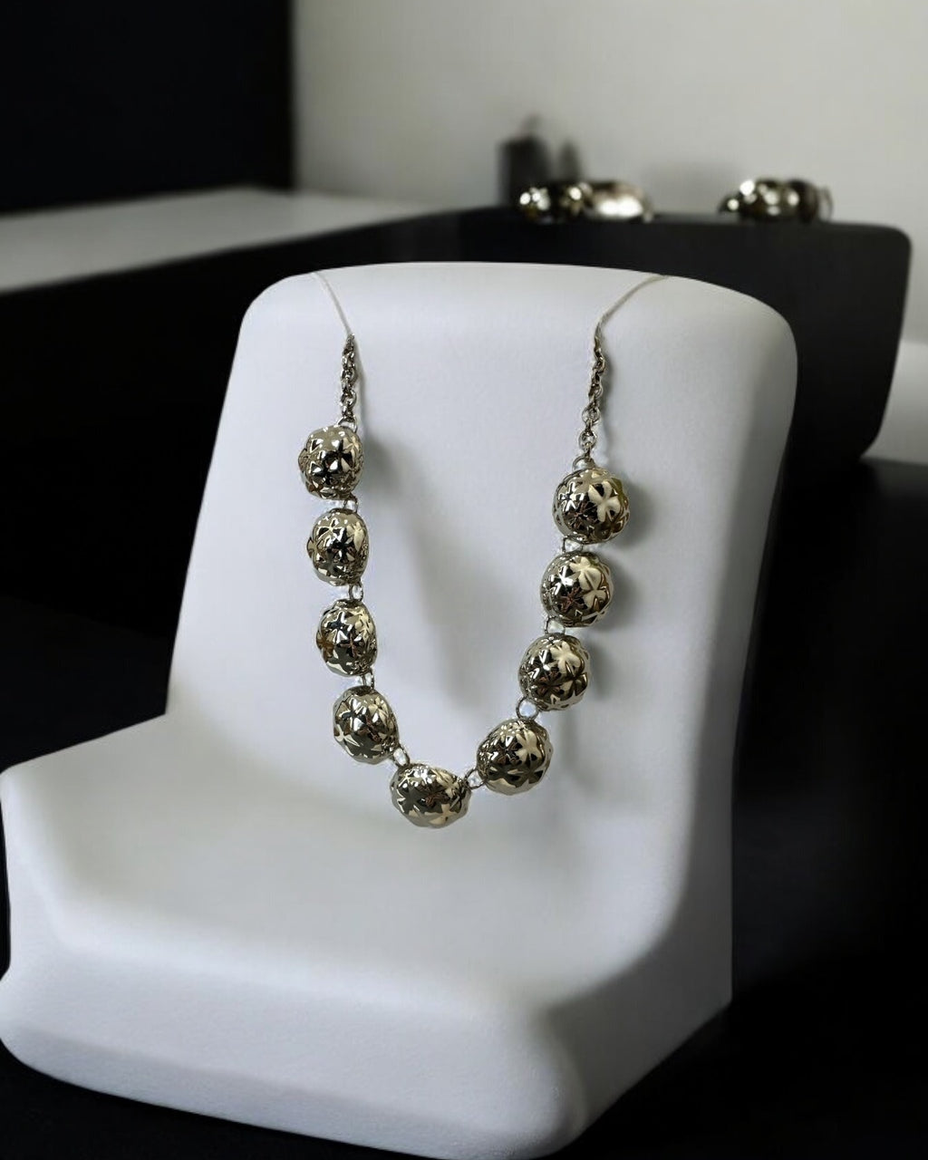 Colar Jamile dourado com contas redondas, estilo gola, em suporte branco
