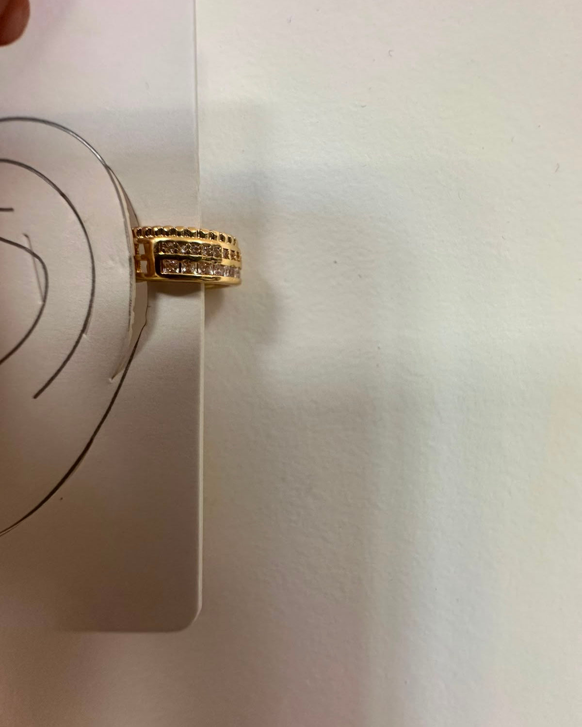 Piercing auricular dourado em aro com fileira de pedras retangulares