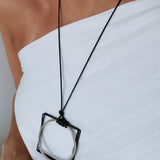 Colar de cordão preto com pingente prateado e detalhe preto em aro