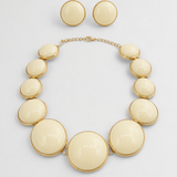Conjunto de colar e brincos com pedras ovaladas bege-claro e acabamento dourado