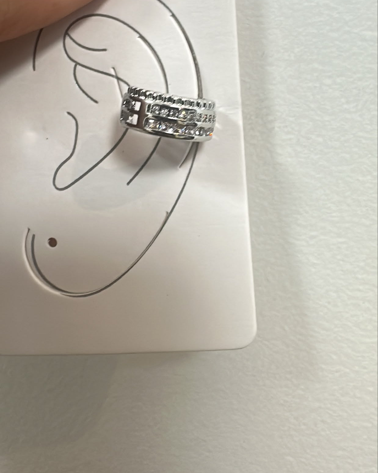 Piercing auricular prateado em aro com fileira de pedras brilhantes