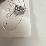 Piercing auricular prateado em aro com fileira de pedras brilhantes