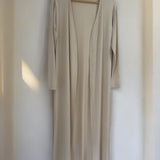 Cardigan longo bege com decote em V e mangas 3/4, aberto na parte frontal.
