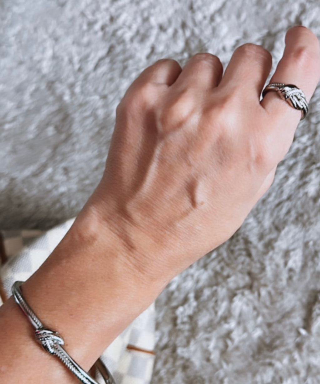 Pulseira prateada com pingentes de nozinho no pulso