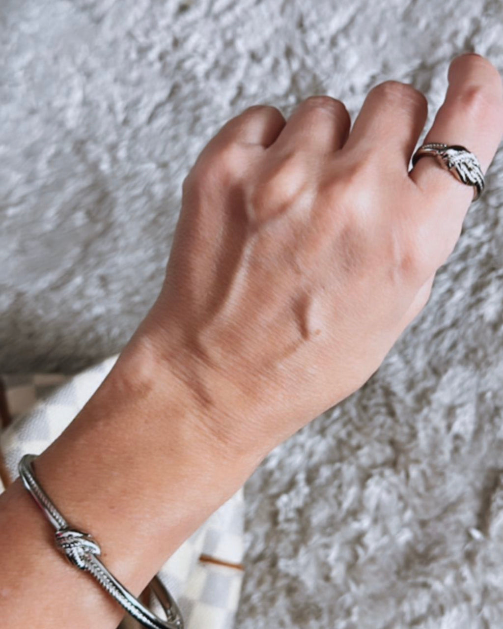 Pulseira prateada com pingentes de nozinho no pulso