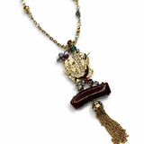 Colar dourado com pingente central detalhado e corrente com tassel marrom escuro