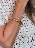 Bracelete Coco em metal com duas pérolas na pulseira aberta