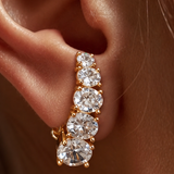 Brinco ear hook dourado com três pedras redondas transparentes