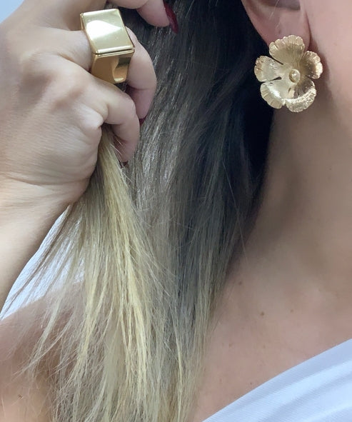 Brinco dourado em formato de flor com pétalas, preso tipo tarraxa