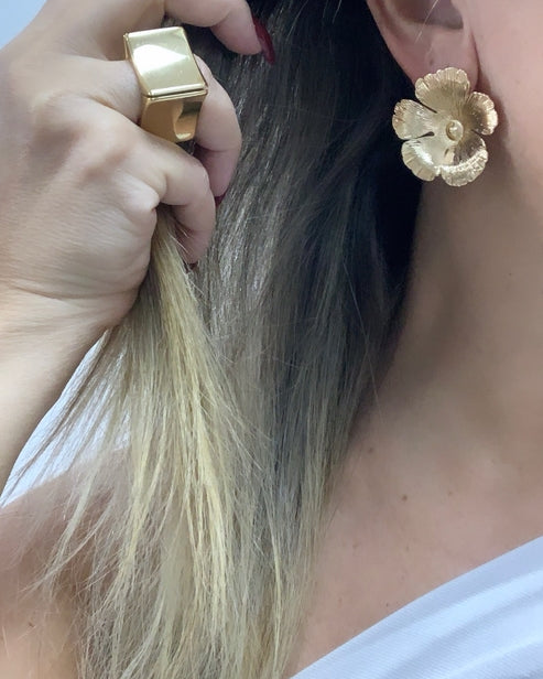 Brinco dourado em formato de flor com pétalas, preso tipo tarraxa