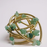 Pulseira folheada dourada com pedras verde-claras em cubos e elos curvos