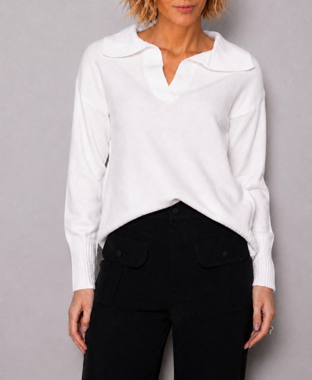 Suéter polo de tricô branco, gola e abertura em V com detalhe inferior canelado