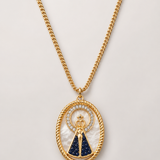 Colar dourado com medalhão oval dourado e fundo azul com símbolo religioso central