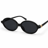 Óculos escuros pretos com lentes ovais e armação fina, detalhe dourado nas hastes