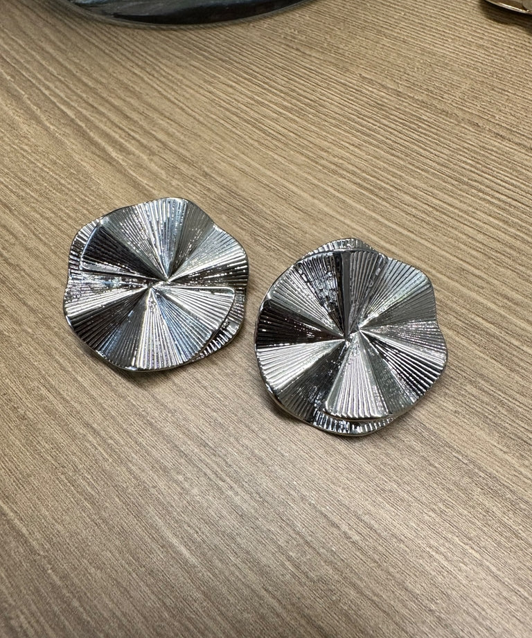 Par de brincos prateados em formato circular com textura radial