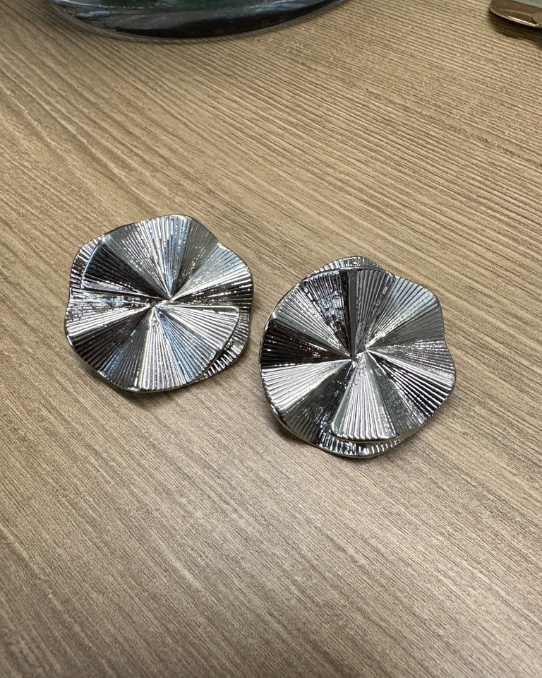 Par de brincos prateados em formato circular com textura radial