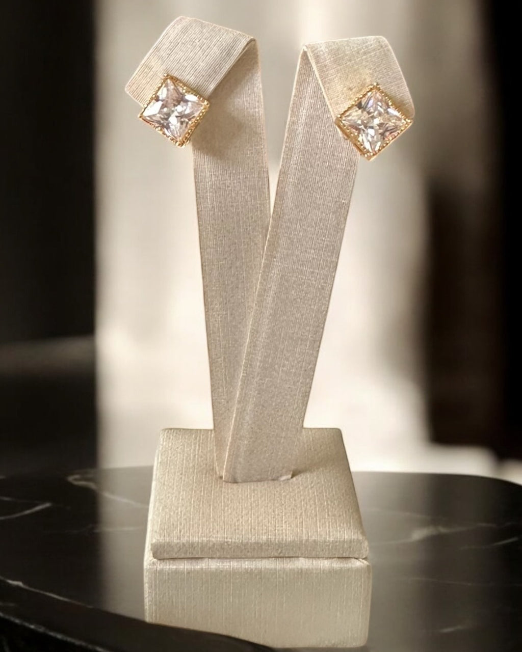 Brinco dourado com pedra quadrada transparente em moldura