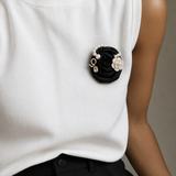 Broche flor preta com pérolas falsas e detalhe dourado