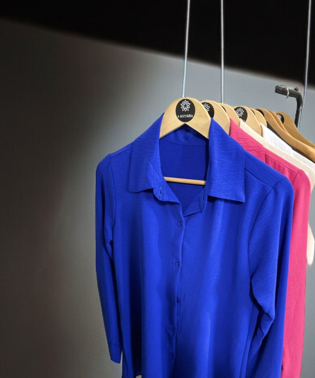 Camisas azul bic penduradas, manga longa, colarinho e botões frontais