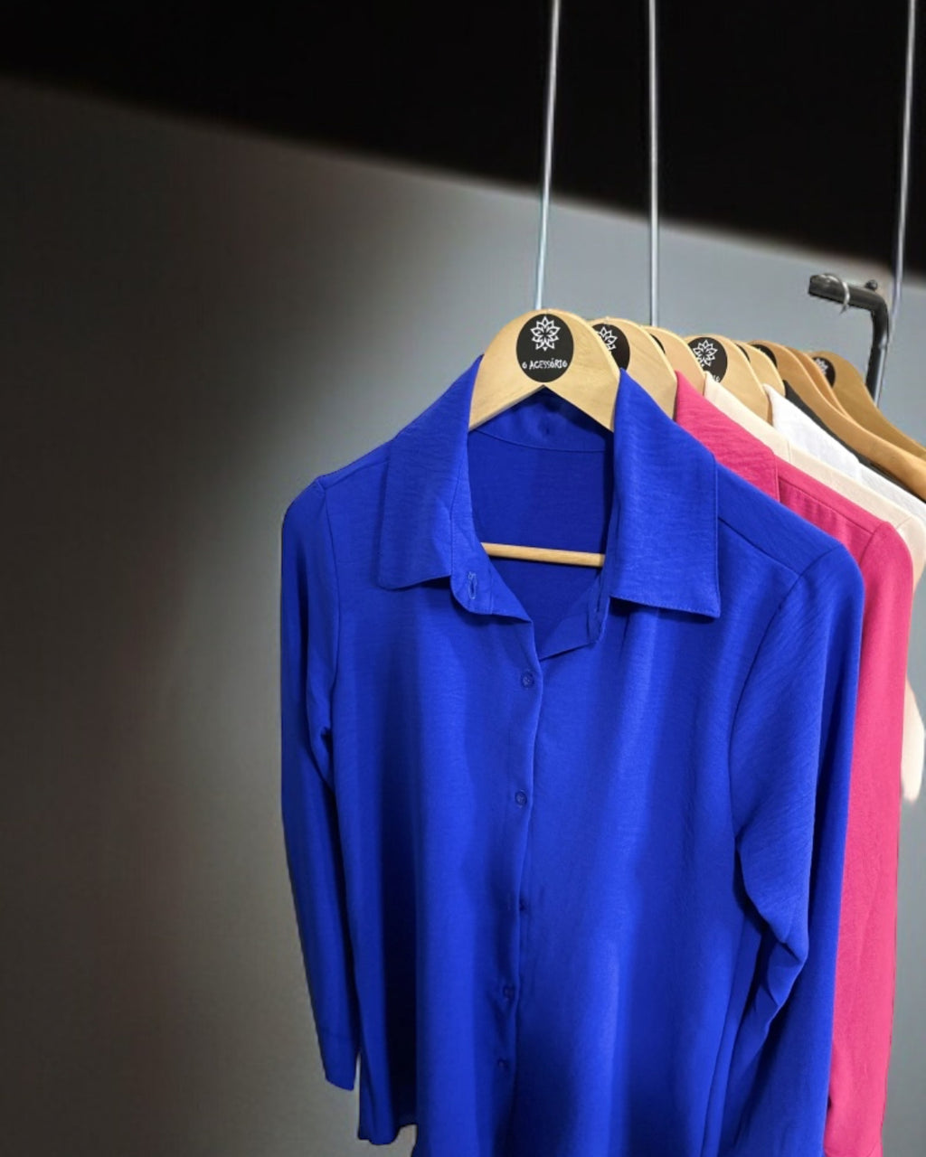 Camisas azul bic penduradas, manga longa, colarinho e botões frontais