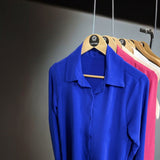 Camisas azul bic penduradas, manga longa, colarinho e botões frontais