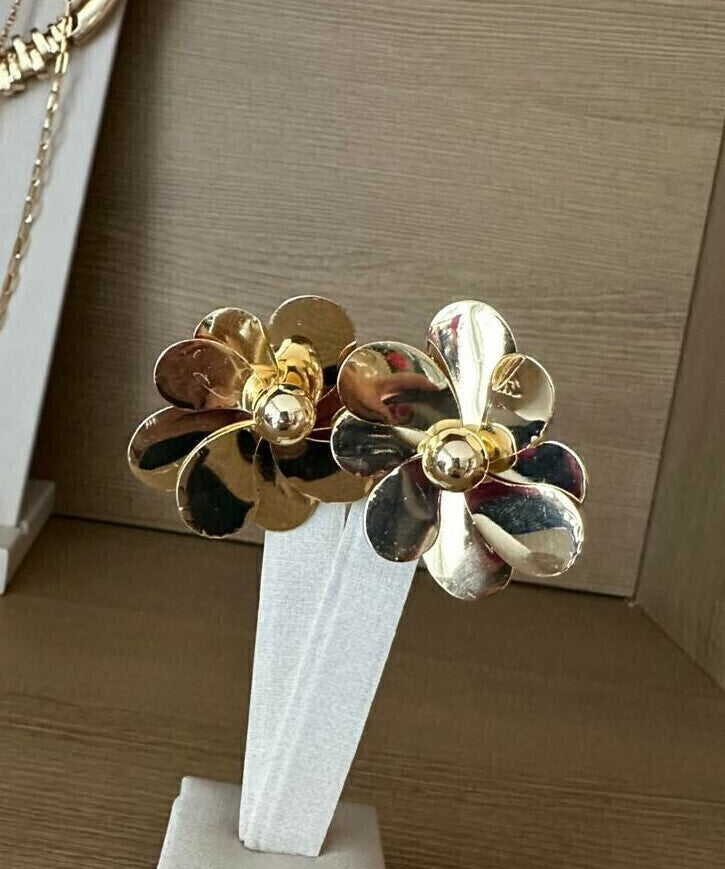 Brinco de flor dourada com pétalas metálicas e detalhe central em formato redondo