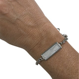 Pulseira com placa retangular prateada e corrente prateada com elos