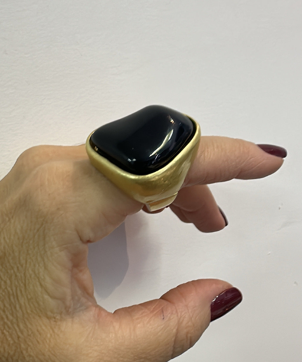 Anel com pedra oval preta em moldura dourada, design abaulado