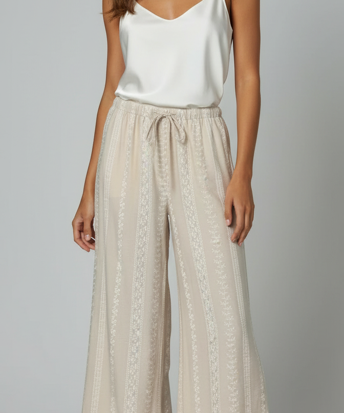 Calça pantalona creme com estampa vazada delicada e cintura com cordão