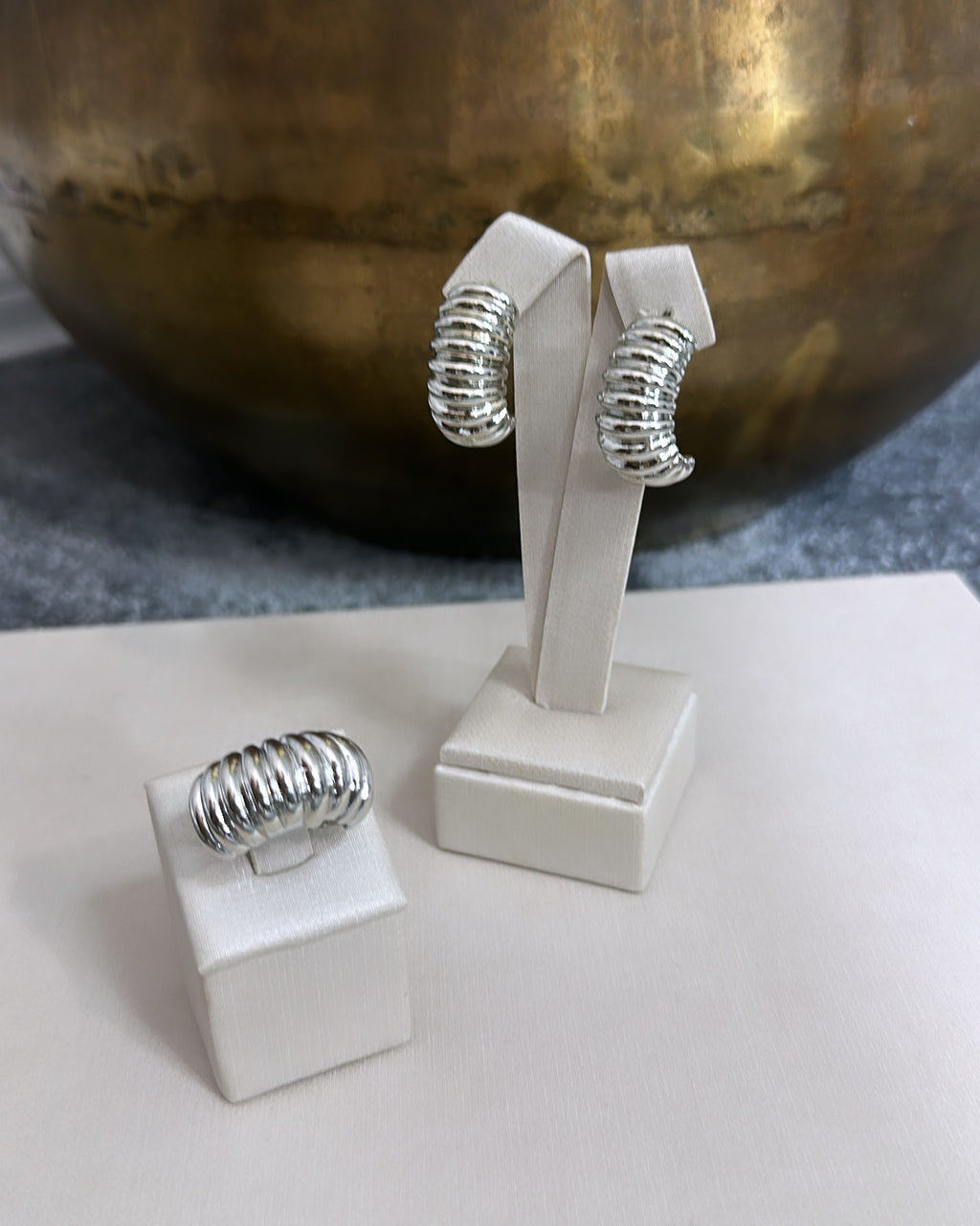 Brinco de argola prateado com textura ondulada