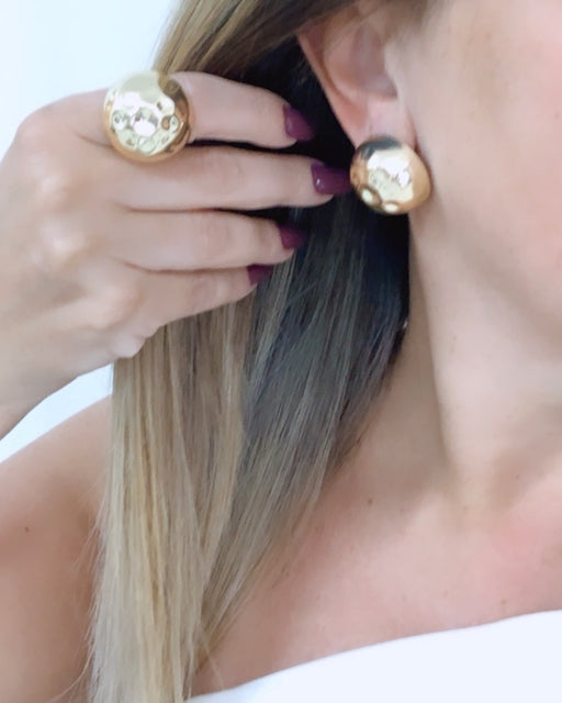 Brinco dourado redondo com detalhe floral e textura brilhante