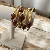 Pulseira de argolas douradas com contas marrons e esferas douradas
