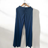 Calça azul escura com cós franzido, detalhe central e modelagem pantalona