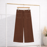 Calça jeans marrom com cós e passantes, bolsos frontais e barra reta.