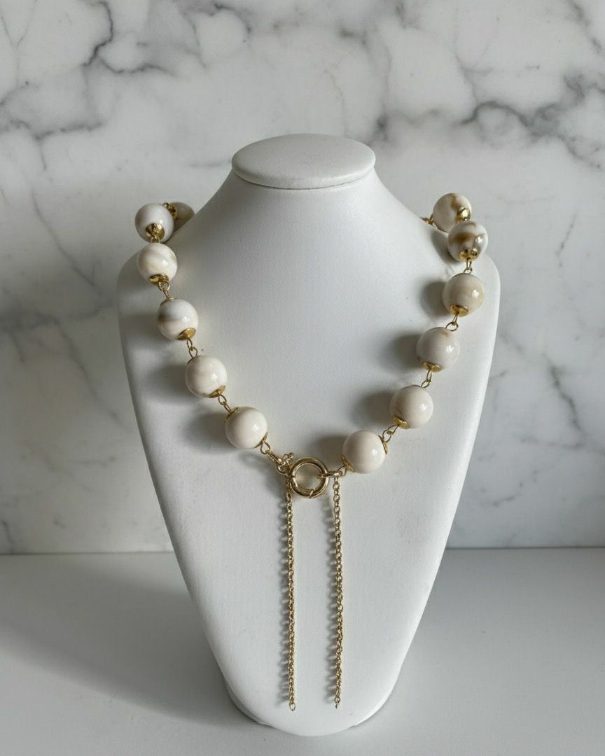 Colar Gloria Slim com contas off-white e fecho dourado, correntes duplas pendentes.