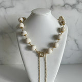Colar Gloria Slim com contas off-white e fecho dourado, correntes duplas pendentes.