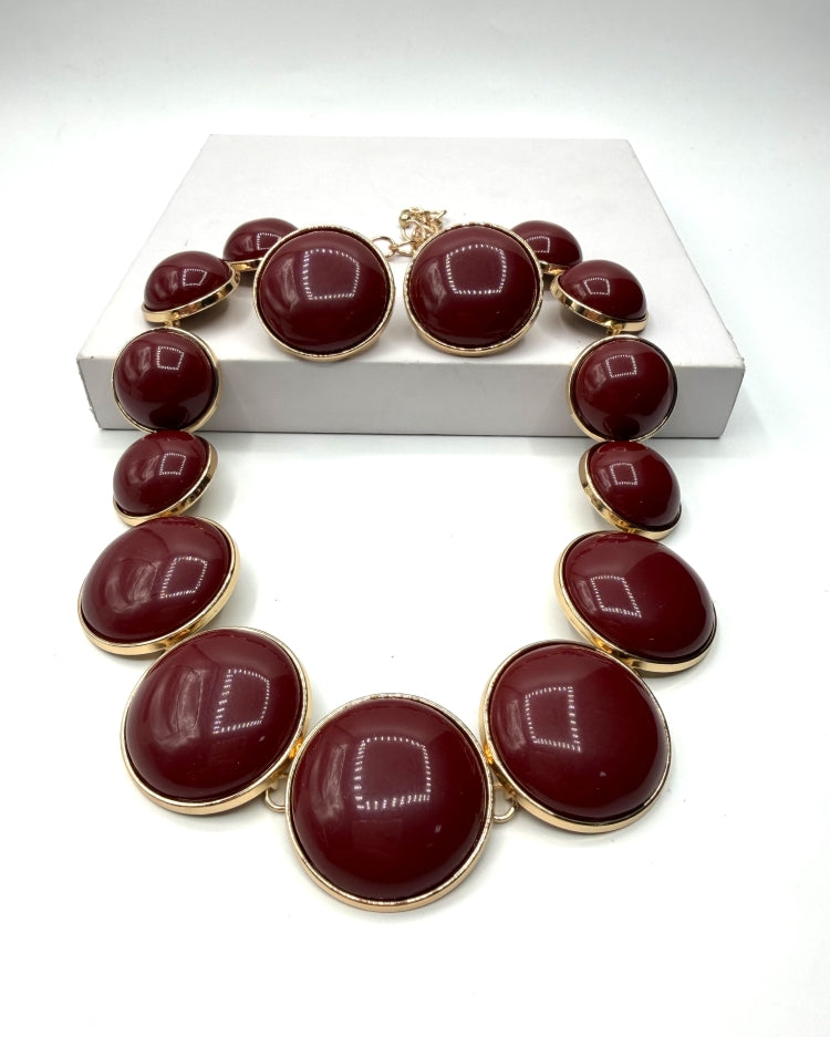 Conjunto de colar e brincos com pedras ovaladas vinho e acabamento dourado