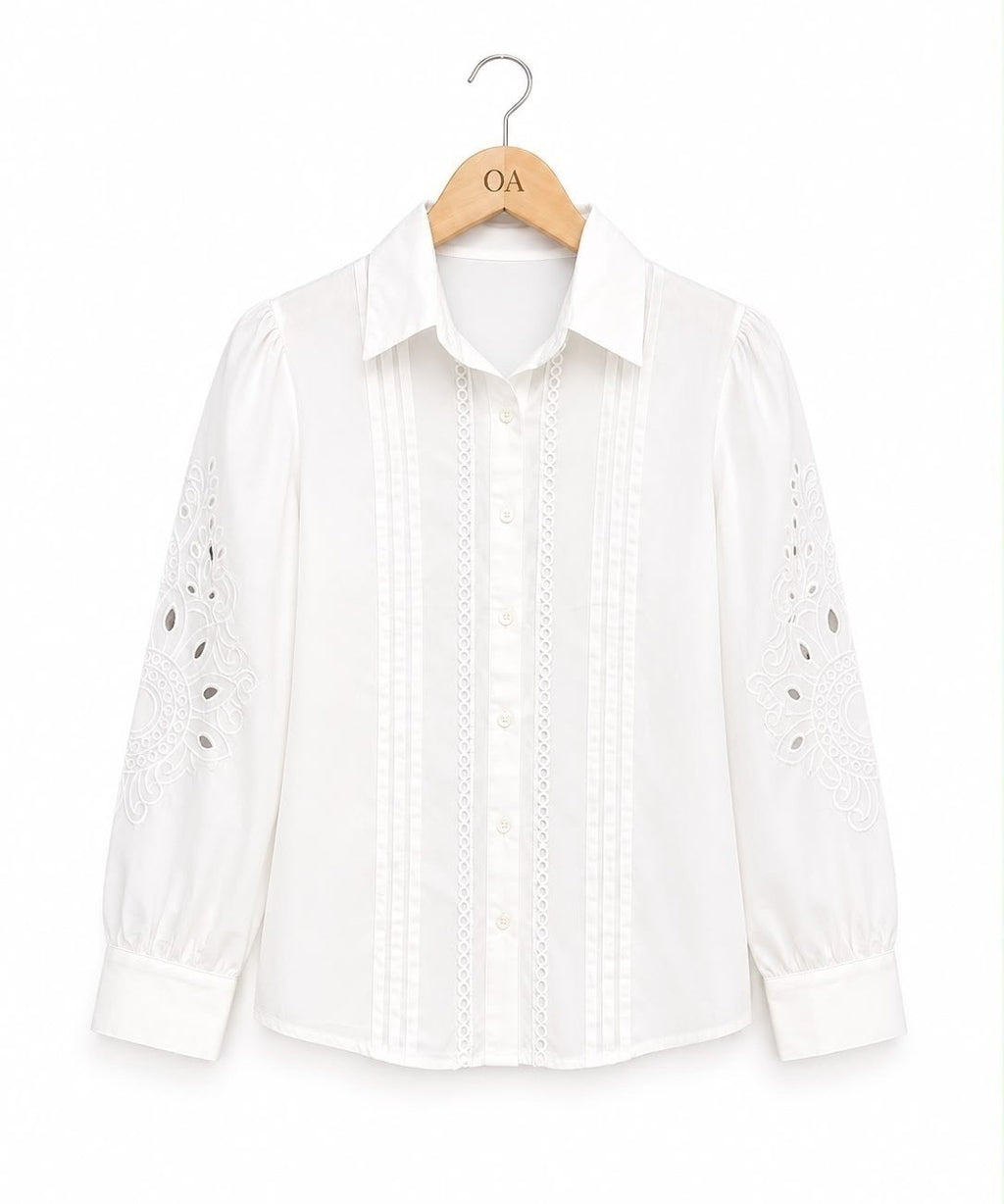 Camisa branca com botões, faixa de bordado vertical e recortes vazados nas mangas