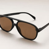 Óculos Emma com armação preta e lentes marrom-escuro estilo aviador