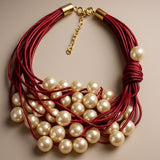 Colar de cordão vermelho com pérolas brancas e fecho dourado